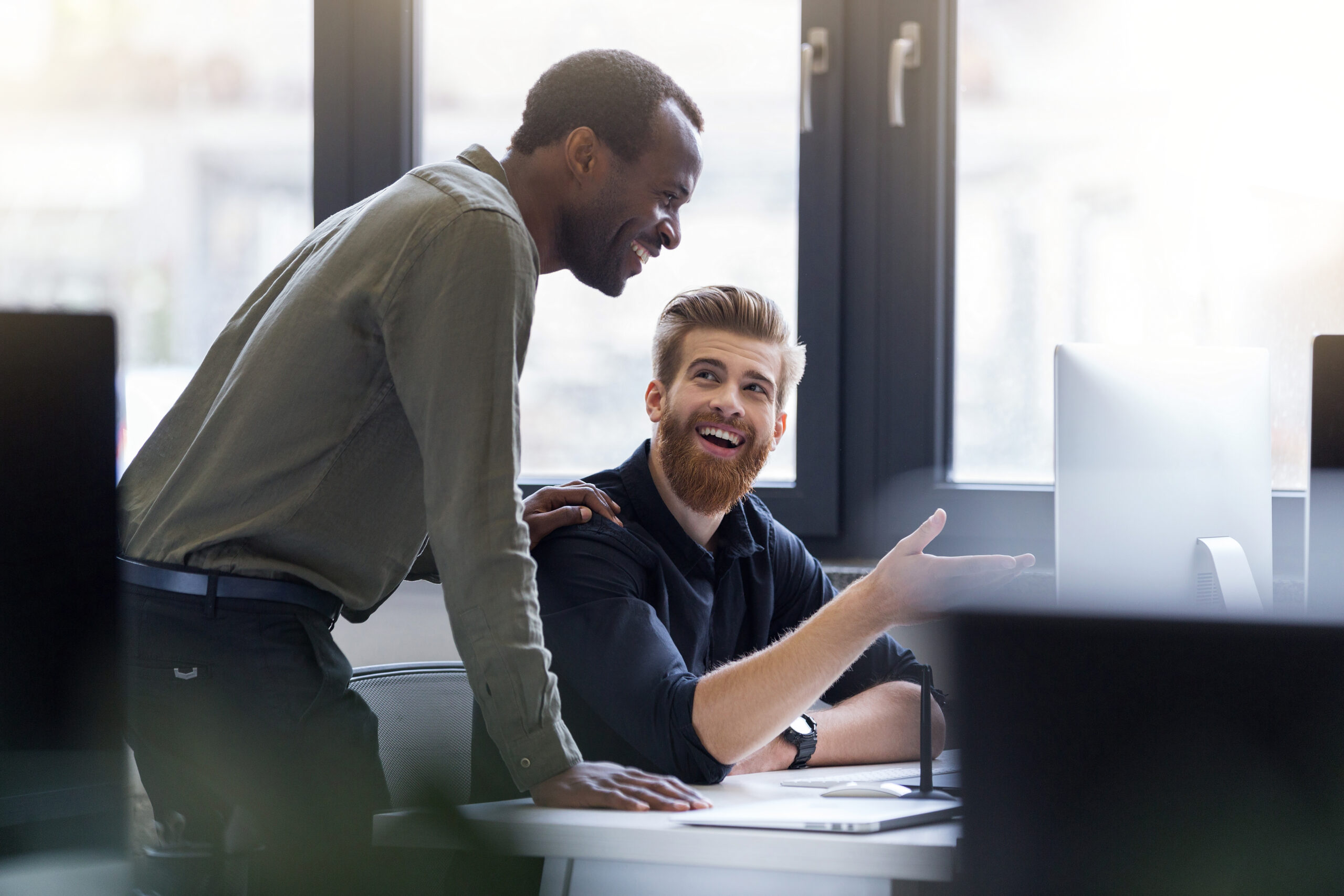 two-happy-men-working-together-new-business-project-scaled